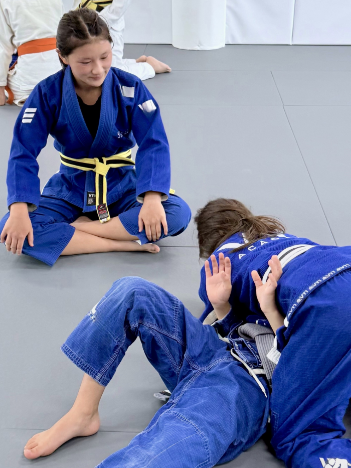 Student in Equinox's leadership program supervising junior students performing Brazilian Jiu-Jitsu drills