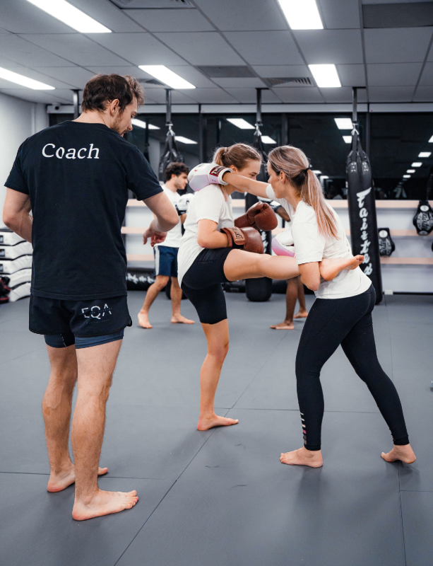 Women Muay Thai students training under the guidance of Equinox Academy coach