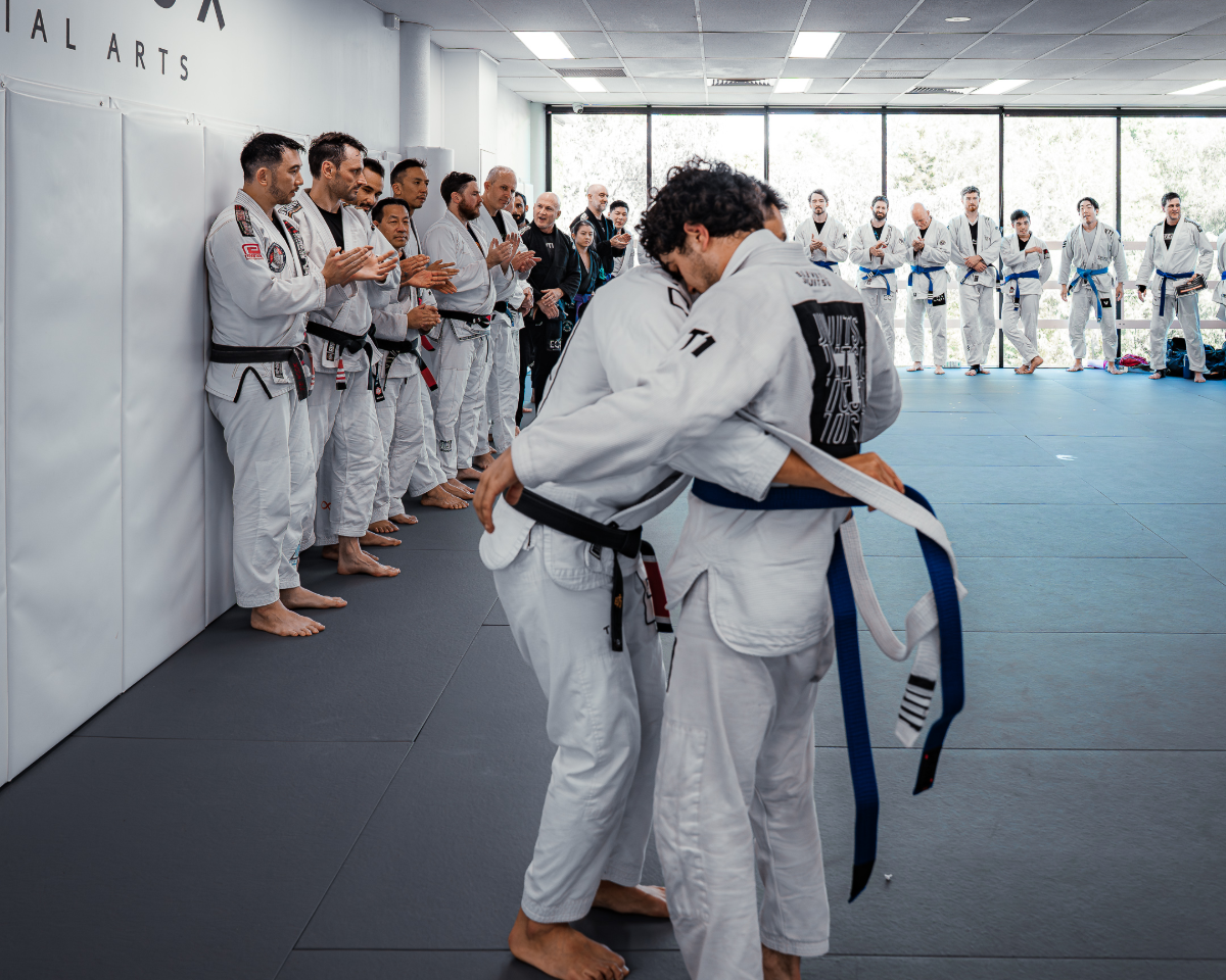 Student receiving his blue belt in Brazilian Jiu-Jitsu (BJJ) from head coach James at Equinox Academy